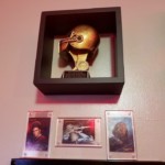My one fantasy football champ trophy and more Trek items Fantast Football trophy and 3 Trek collectible cards in frames on the wall