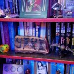 More books and a Klingon artifact with "Chris" in Klingon more books by Terry Brooks, Isaac Asimove, Stephen R. Donaldson, Frank Herbert and others with more knicknacks in front