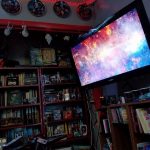 West Wall closet and Viewscreen #1! Closet showing collection of sci fi and fantasy books, other memorabilia, Star Trek ornaments and plates, and one of two flatscreen TVs. A starfield YouTube vido plays on the TV.
